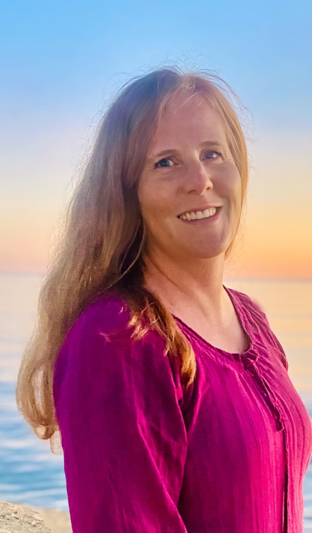 Shannon Rizzuto smiling by the water at sunset